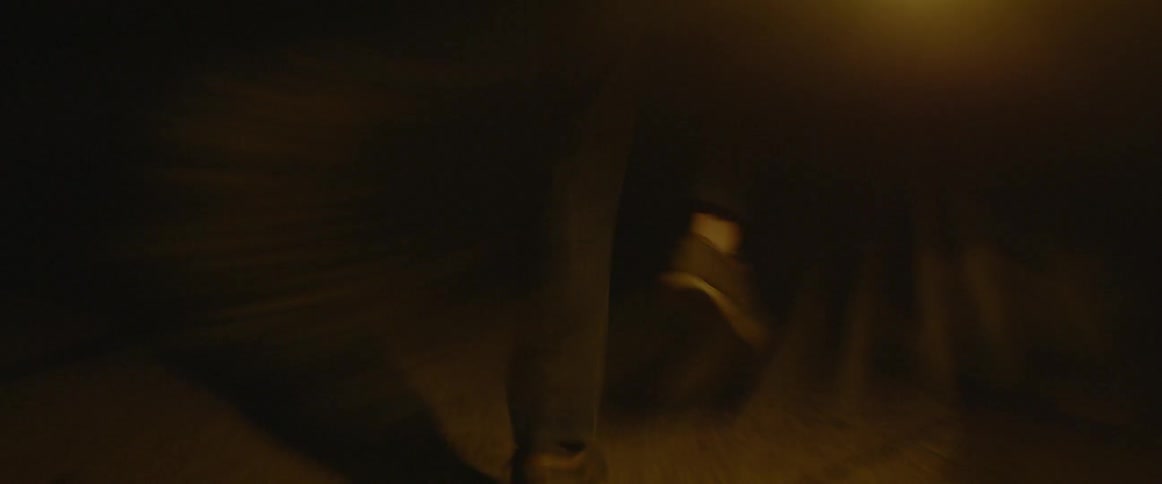 A person runs across concrete in the dark