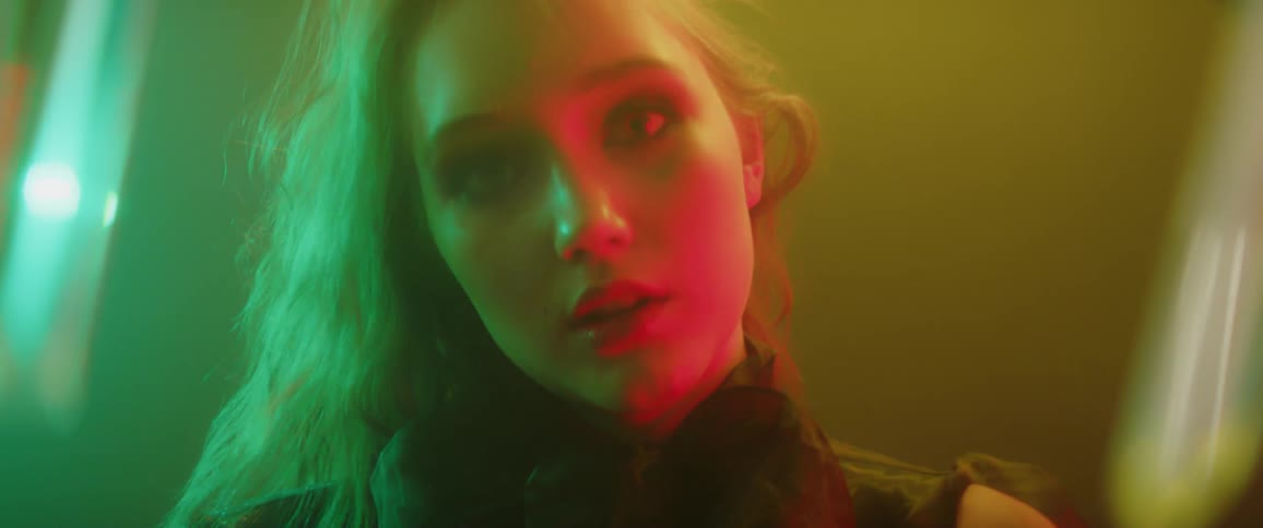 Woman standing under different colored lights