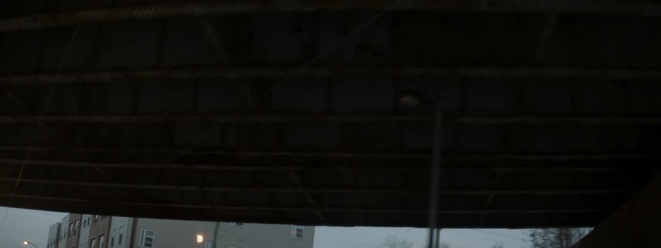 Buildings and a bridge sit under a cloudy sky