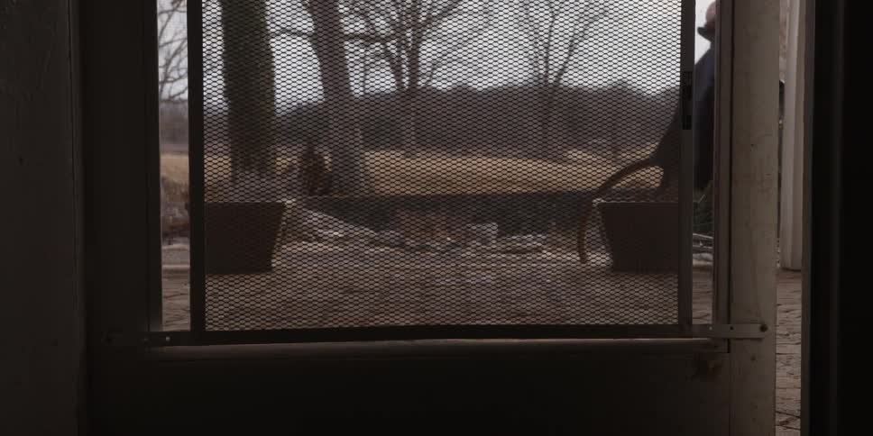 A biker gets off his bike at home