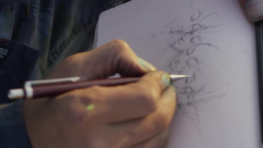 A man sketches in a journal outside