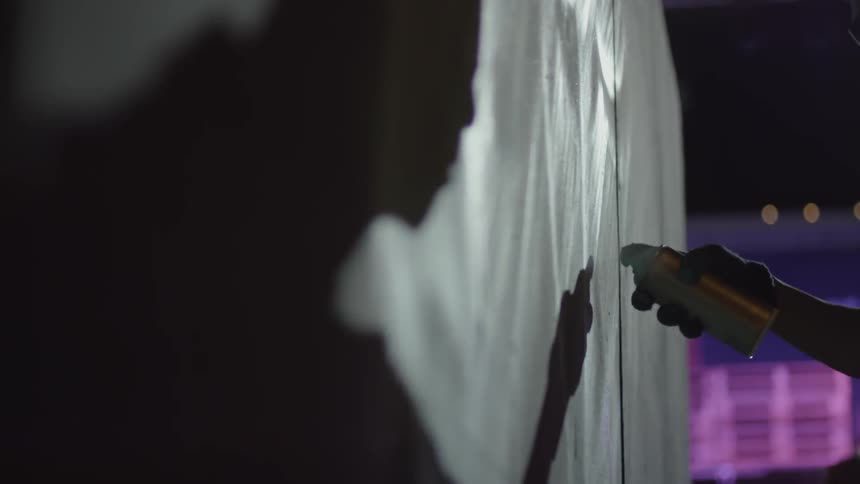 A man spray paints a wall