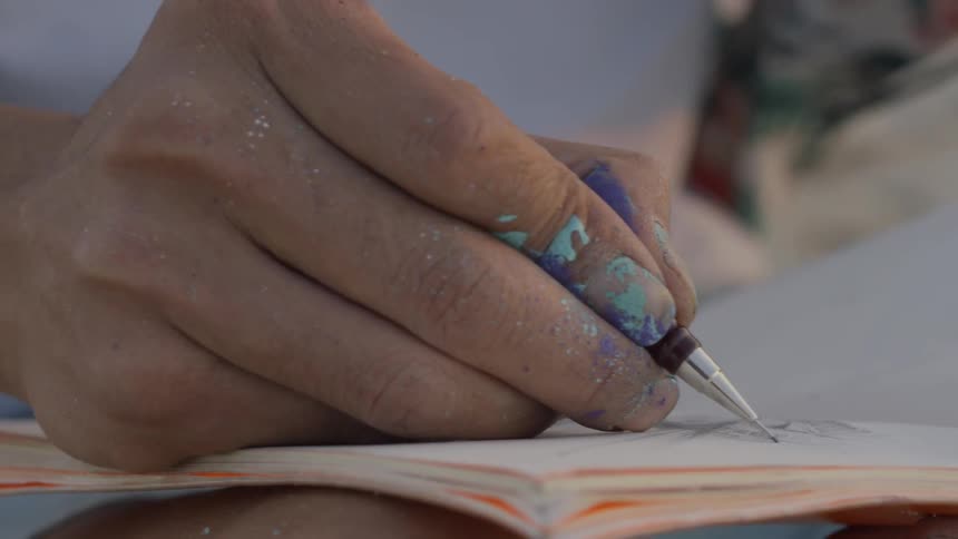 A person draws in a journal