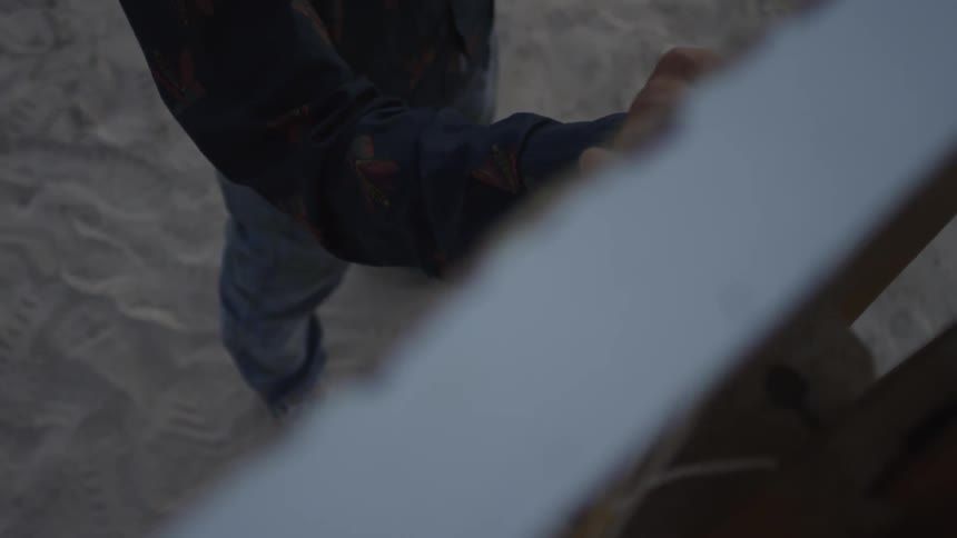 A man paints on a canvas outside