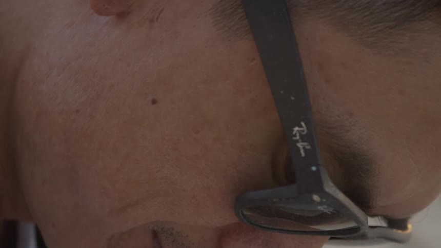 A person smiles as he looks down