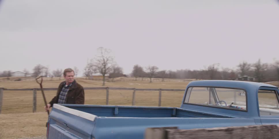Man gets out of his truck grabs a shovel from the back and walks in a fence