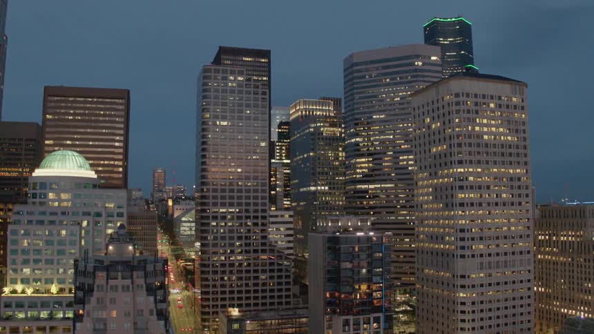 Evening lights from skyscraper windows and traffic moving on city streets