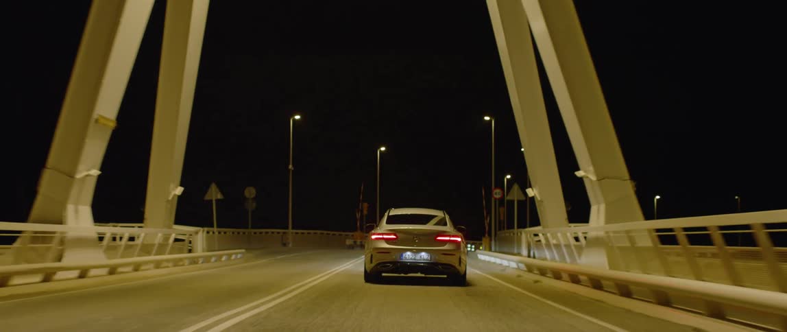 Car drives on a bridge at night