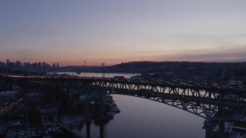 Evening rush hour traffic crossing a bridge over calm water