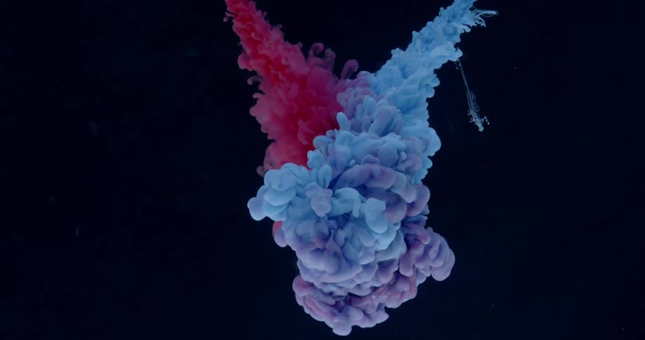 Billowing clouds of colored dye are falling through water and mixing