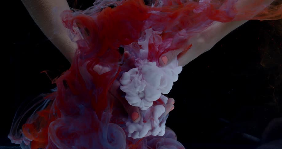 Dye flows around a woman's hands