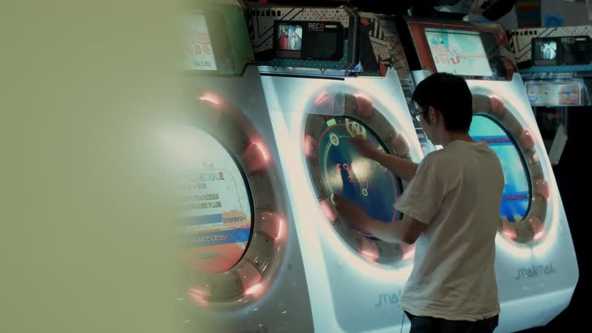 A man is playing an arcade machine inside