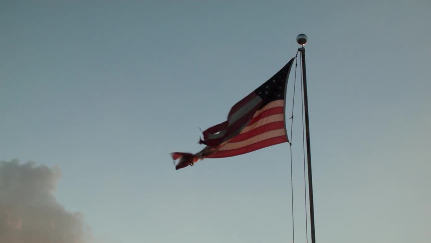 A torn american flag waves in the wind