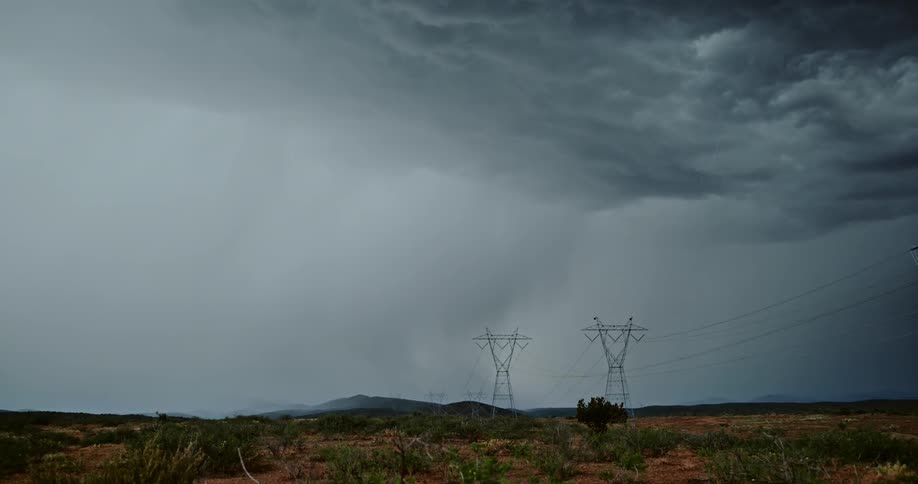Storm clouds and lightning bolts over fields and power lines