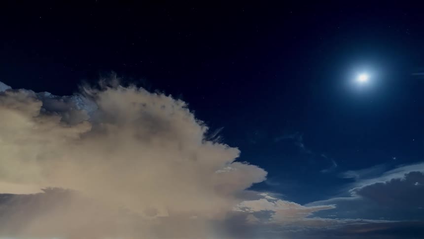 The large clouds move across the dark sky