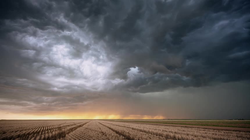 Dark clouds float over a field as lightning flashes