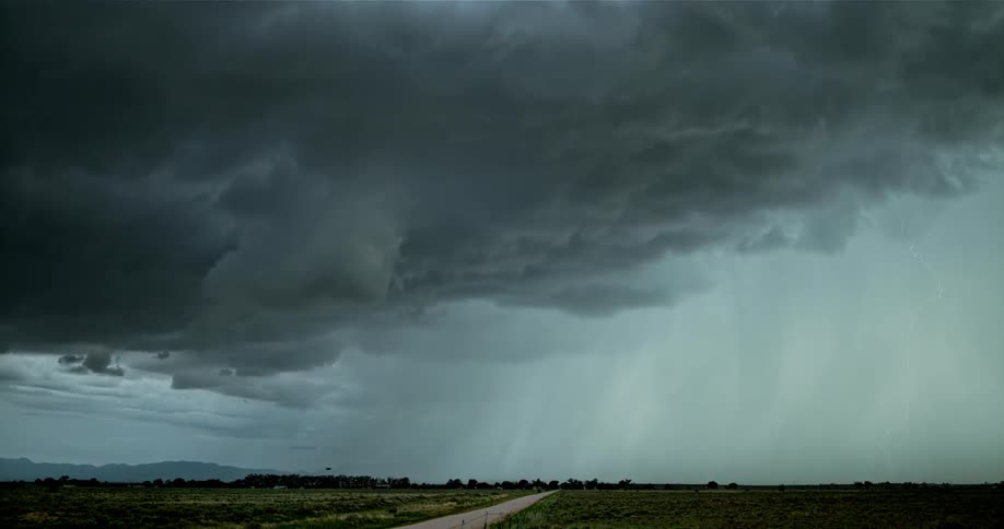 Lightning flashes brightly in the dark cloudy sky