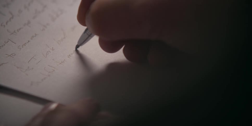 A person writing on a piece of paper