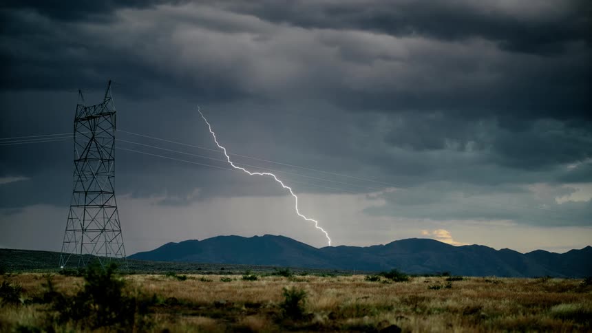 Lightning flashes behind the mountain