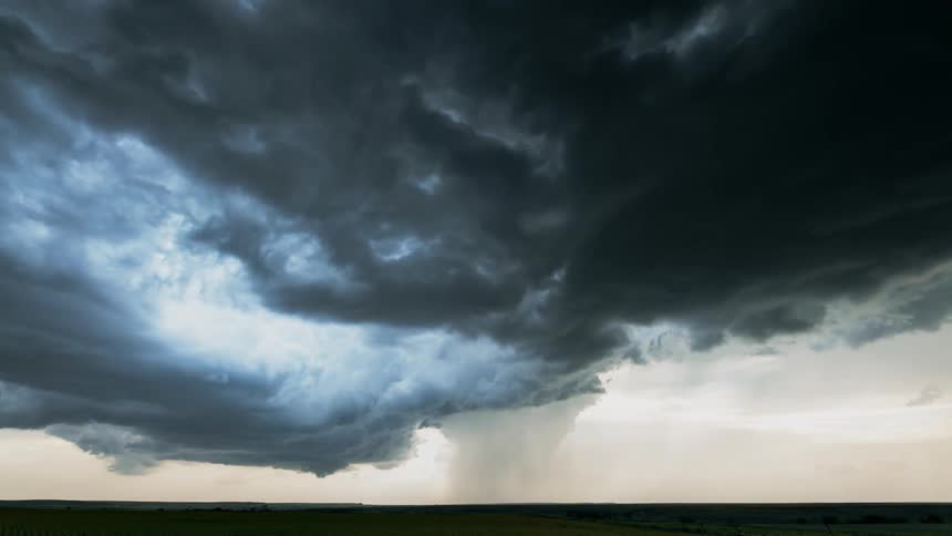 Storm clouds float over a rural field