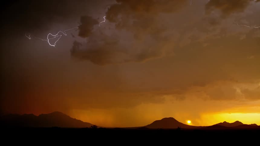Lightning flashes in the storm clouds at dawn