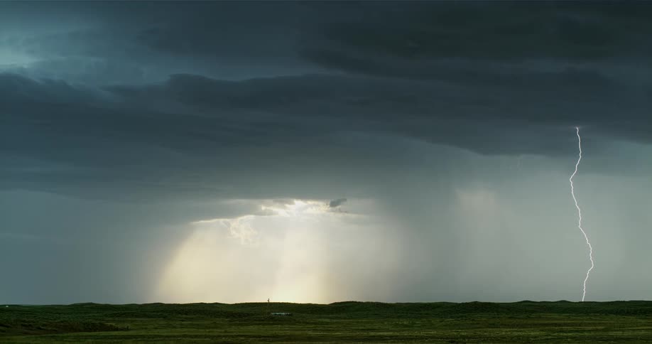 Storm clouds pour rain and lightning is falling all over