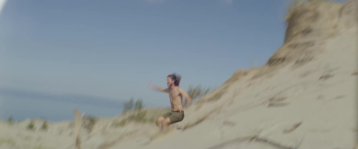 Man jumps off of a sand hill
