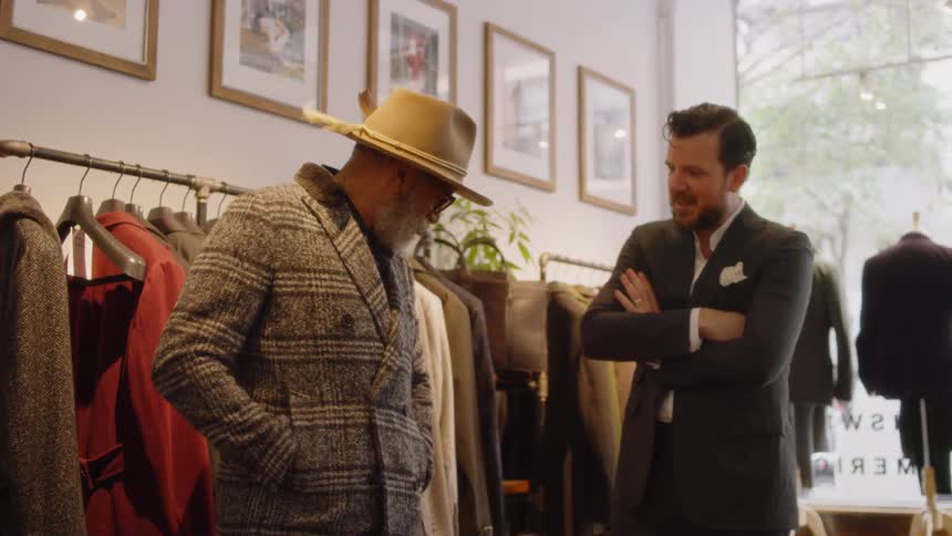 Two men talk in a clothing store