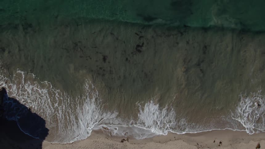 Waves crash into the sandy beach
