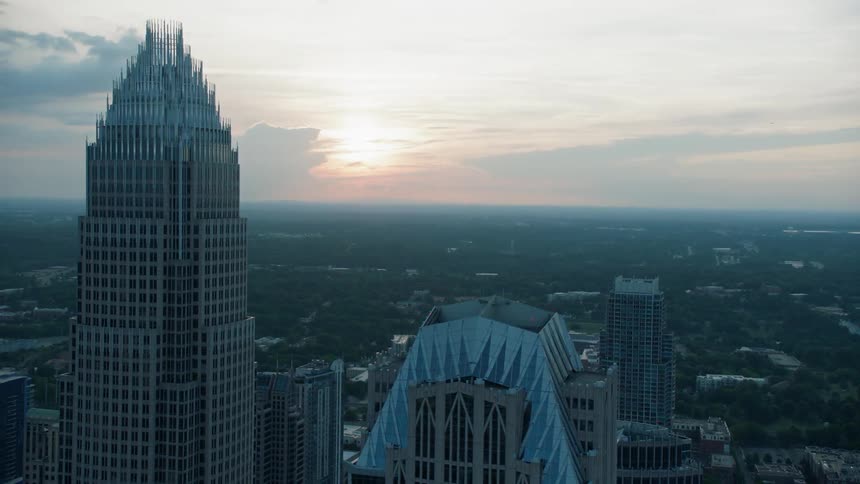 The sun is rising over the horizon beyond a city