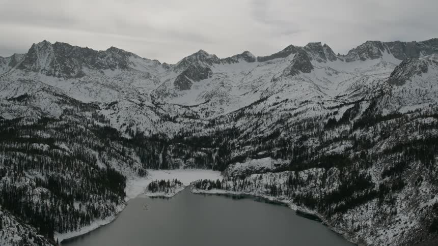 Clouds hang in the sky over a mountain lake in winter