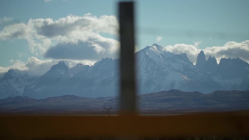 Clouds float over snowy mountains