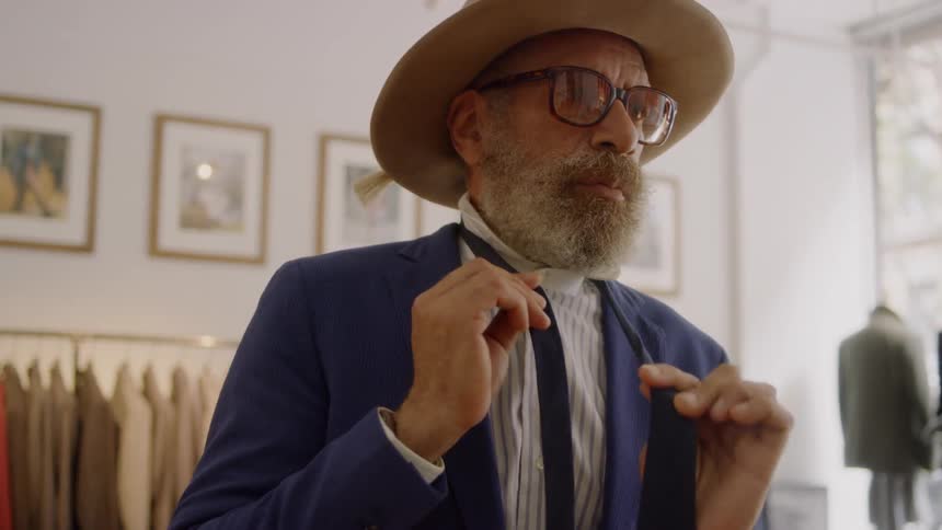 Man tries on a blue tie in a clothing store