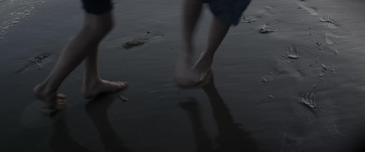 Children walk in the wet sand at the beach