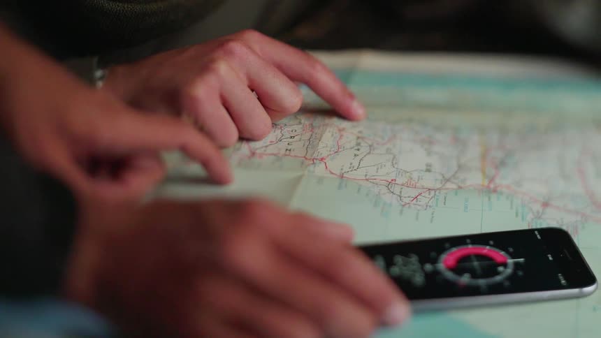 Man and woman use a compass as they look at a map