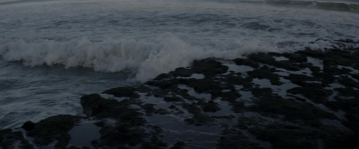 Waves crash into shore and then recede