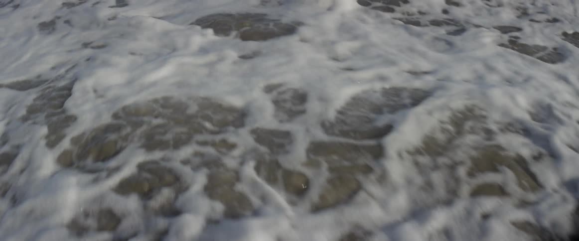 Ocean waves wash ashore a sandy beach