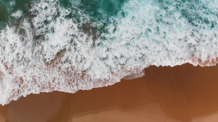 Ocean waves wash ashore a sandy beach