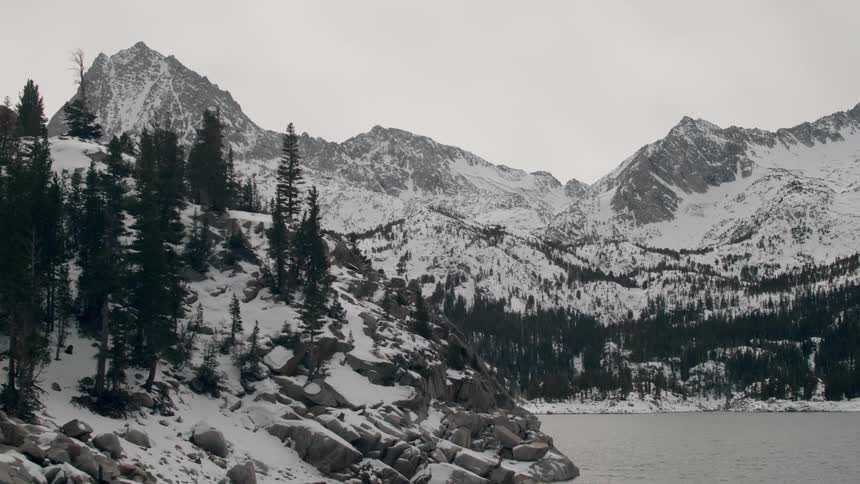 A lake leads to a snow covered mountain