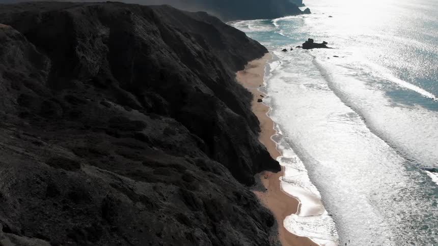 Ocean waves wash ashore a sandy beach