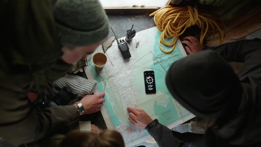 People gather at a table and review a map