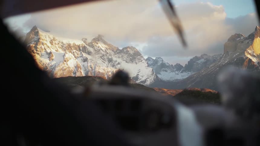 People are taking in the view of a mountain range from the cab of their vehicle in daylight