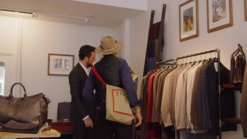 A salesman shows jackets to a customer