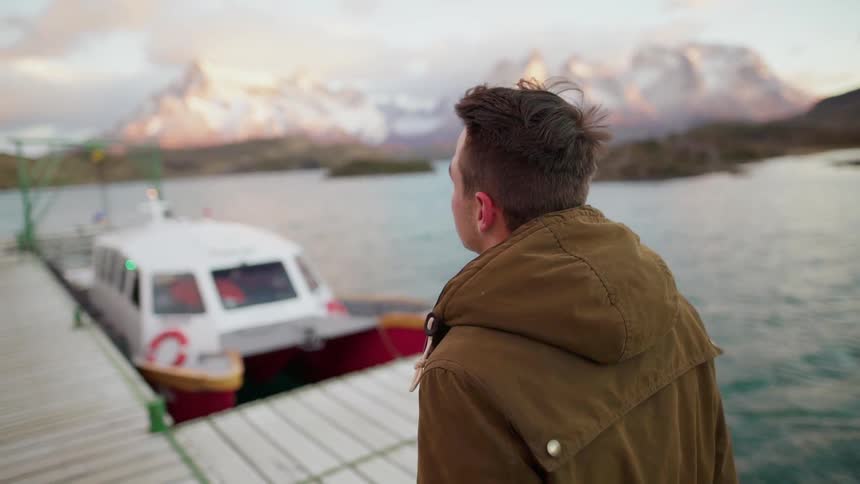 A man walks on a lake dock