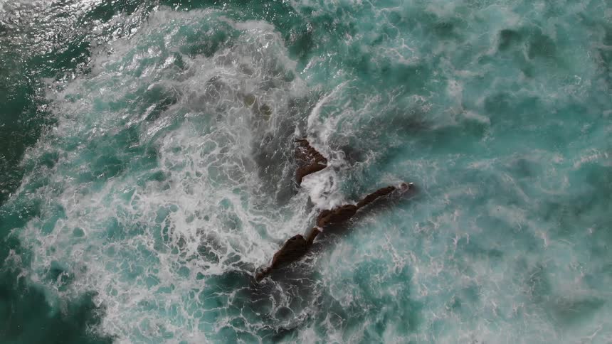Waves crash over the rocks in the ocean