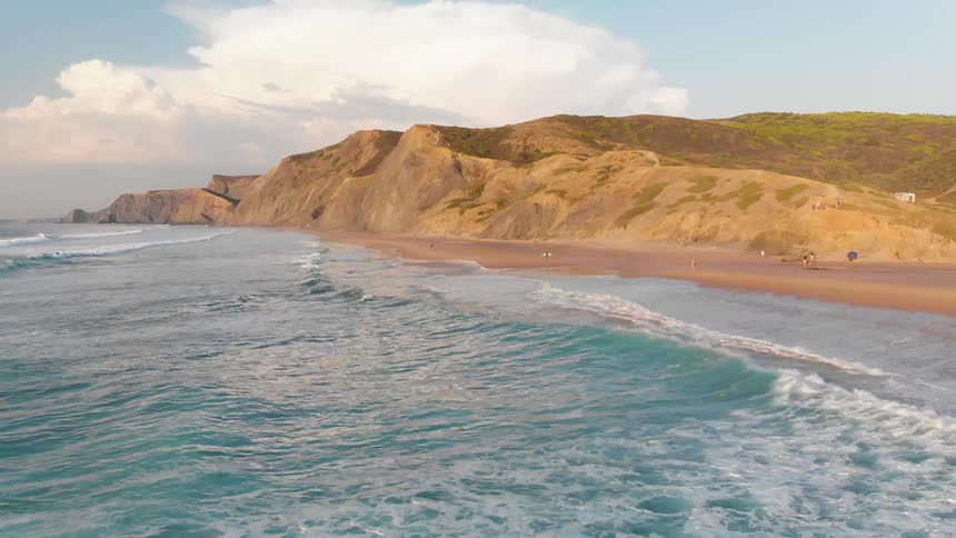 Waves roll into the sandy beach