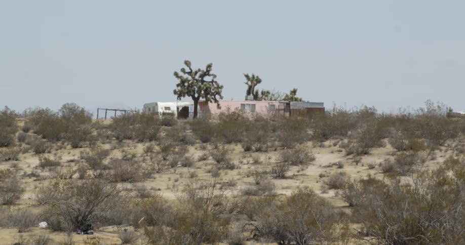 The desert hill leads to a trailer on top