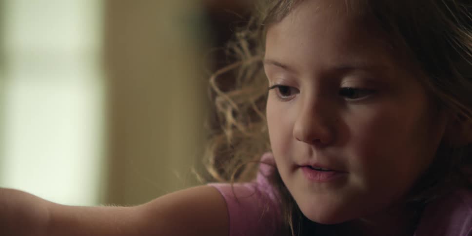 A young girl smiles and talks