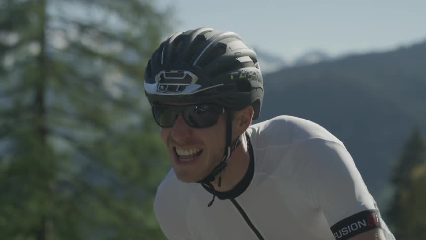 A man is struggling as he rides his bike uphill