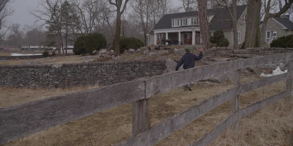 Boy running up some stone steps towards a home